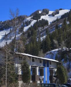 a house on the side of a snow covered hill at St Moritz Lodge and Condominiums in Aspen