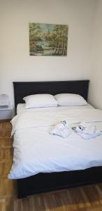 een bed met witte lakens en 2 handdoeken erop bij Zlatiborski potok in Zlatibor