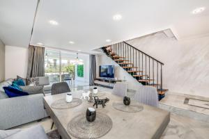 uma sala de estar com uma mesa e um sofá em Luxury Townhouse Golden Mile em Marbella