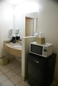 a microwave sitting on top of a counter in a bathroom at Colony Inn in Buena Park
