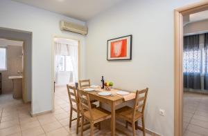 een eetkamer met een houten tafel en stoelen bij TownHall Apartment's in Rhodos-stad