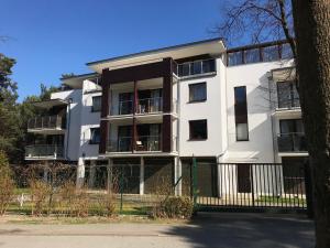 Biały budynek z płotem przed nim w obiekcie Apartament Fala Bryza w Juracie +9 zdjęć