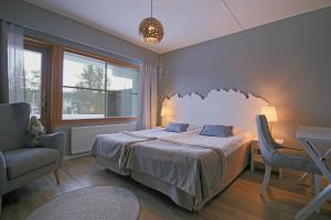 ein Schlafzimmer mit einem Bett, einem Stuhl und einem Fenster in der Unterkunft Santa's Hotel Tunturi in Saariselkä