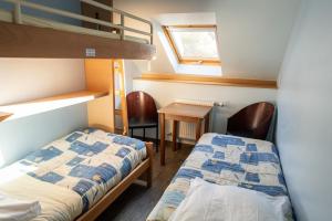 Cette chambre comprend deux lits, un bureau et des lits superposés. dans l'établissement Aux Studios du Parc, à Plombières-les-Bains