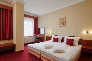 a hotel room with a bed with towels on it at Wellness Hotel Lužan in Rumburk