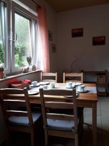 Una mesa de comedor con sillas y una ventana. en Ferienwohnung Am Rauenstein, en Struppen 4 fotos más