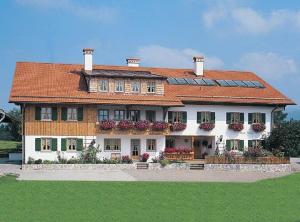 une grande maison avec des panneaux solaires sur son toit dans l'établissement Landhaus Beim Joaser, à Schwangau