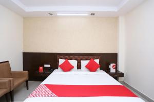 a bedroom with a large bed with red pillows at Hotel Le central in Haridwār