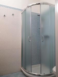 オストゥーニにあるAurasia Alla Marinaのバスルーム(ガラスドア付きのシャワー付)