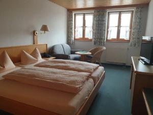 a bedroom with a bed and a living room at Landhaus Beim Joaser in Schwangau