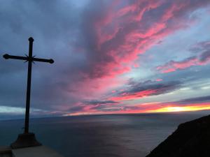 a cross on top of a hill with a sunset at Tramonto sul Mare in Framura