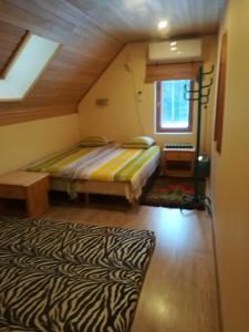 een kleine slaapkamer met een bed en een raam bij Kõrgemäe puhketalu in Eoste