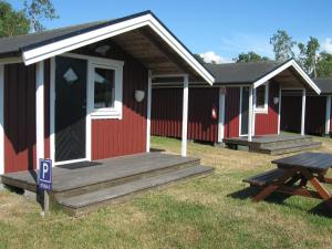 a red and white building with a picnic table in front of it at Rödlix Vandrarhem & Camping in Tvååker