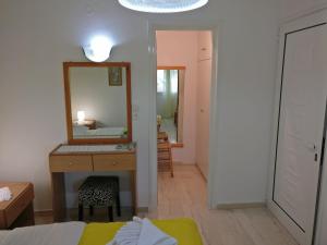 1 dormitorio con tocador, espejo y cama en Villa Artemis en Achlia