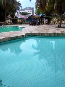 una piscina de agua azul en un complejo en Jean CleanComfy Apt Near Beach, en Batu Ferringhi