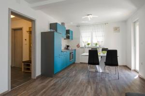 una cucina con armadi blu, tavolo e sedie di Apartment Pula R&D a Pola (Pula)