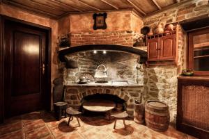 a kitchen with a stone fireplace with stools in it at Chamurkov Guest House in Veliko Tŭrnovo