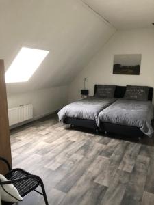ein Schlafzimmer mit einem Bett und einem Dachfenster in der Unterkunft appartement het Stolpje in Julianadorp