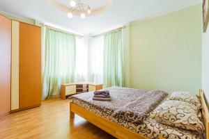 a bedroom with a bed and a desk in a room at Апартаменты возле МВЦ in Kyiv