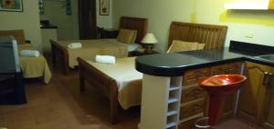 a room with two beds and a kitchen with a counter at Happy Ripples Beach Resort in Mabilao