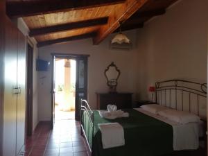 a bedroom with a bed with a green blanket at Villa Incanto B&B in Caprioli