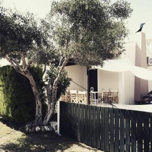 a fence and a tree next to a house at Eleios Villa in Katelios