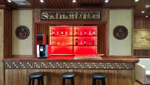 a bar with stools in front of a red counter at Xingping Li River Lodge in Yangshuo