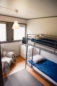 a bedroom with two bunk beds and a desk at Trolltunga/Folgefonna Camp house in Jondal