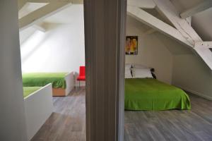 een slaapkamer met een groen bed op een zolder bij Gîte Duras in Souillac