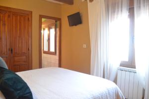 - une chambre avec un lit blanc et une fenêtre dans l'établissement Hostal Refugio De Gredos, à Navarredonda de Gredos