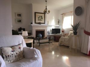 sala de estar con sofá blanco y chimenea en Park Beach, 20, en Estepona