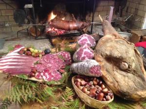 einen Haufen Fleisch und Gemüse auf einem Tisch mit einem Feuer in der Unterkunft San Larenzu in Aullène