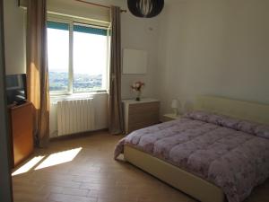 een slaapkamer met een bed en een groot raam bij VISTAMOZZAFIATO AGRIGENTO in Agrigento