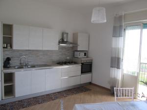 a white kitchen with a sink and a stove at VISTAMOZZAFIATO AGRIGENTO in Agrigento