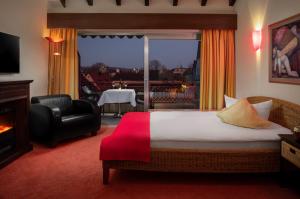 una camera d'albergo con un letto e una grande finestra di Hetzel Hotel Stuttgart a Stoccarda