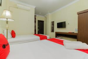 a hotel room with two beds and a television at RedDoorz @ Malalayang 2 Manado in Manado