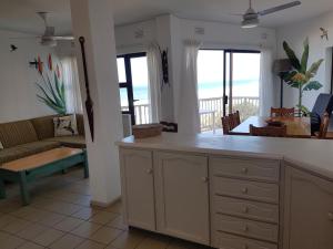 a kitchen and living room with a view of the ocean at Umdloti Beach Apartment in Umdloti