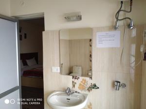 La salle de bains est pourvue d'un lavabo et d'un miroir. dans l'établissement TSASKAN hotel, à Leh