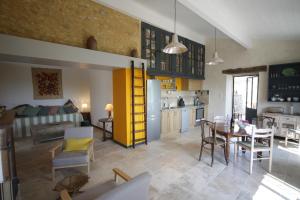 a living room with a kitchen and a dining room at Petite maison Peyrot in Loubejac