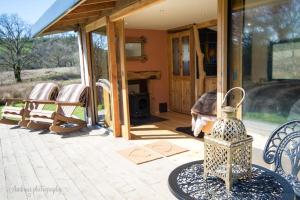 a screened in porch of a house with a fireplace at Serenity Lodge in Llandeilo