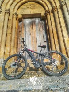 a bike parked in front of a building with a door at Casa Esperança in Castro Daire