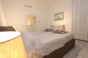 - une chambre avec un grand lit et des serviettes dans l'établissement Lovely Apt Old Town with FREE PRIVATE PARKING included!, à Gênes