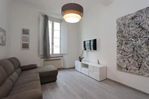 a living room with a couch and a tv at Lovely Apt Old Town with FREE PRIVATE PARKING included! in Genoa