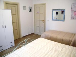 a bedroom with two beds and a dresser and a mirror at B&B Il Cantuccio in Fondi