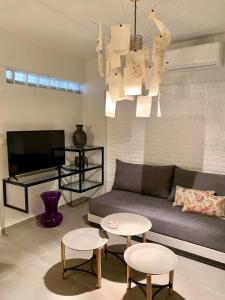 uma sala de estar com um sofá e duas mesas e uma televisão em LILO Central Studios - LIve with LOve em Iráclio