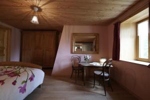 1 dormitorio con 1 cama, mesa y sillas en La Fritillaire, en La Montagne