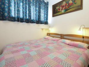 sypialnia z łóżkiem z różową i niebieską kołdrą w obiekcie Apartment Suzana 1849 w Fažanie
