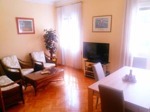 a living room with a table and chairs and a television at Apartamento en Retiro in Madrid