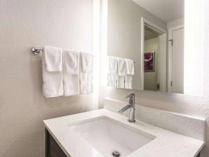 a bathroom with a sink and a mirror and towels at La Quinta by Wyndham Columbia / Fort Meade in Jessup