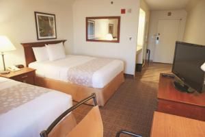 a hotel room with two beds and a flat screen tv at La Quinta by Wyndham Stamford / New York City in Stamford